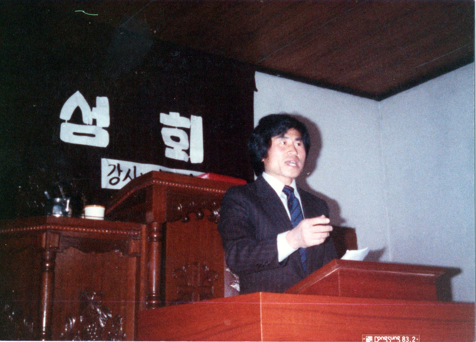 부흥회 강단에서 손을 들어 설교하고 있는 김영수 목사