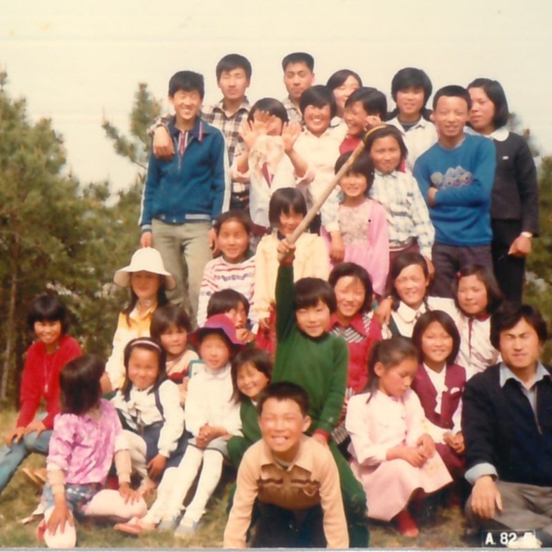 야산 풀밭에 모여 앉은 서탄교회 아이들과 교인들, 오른쪽 아래에 김영수.